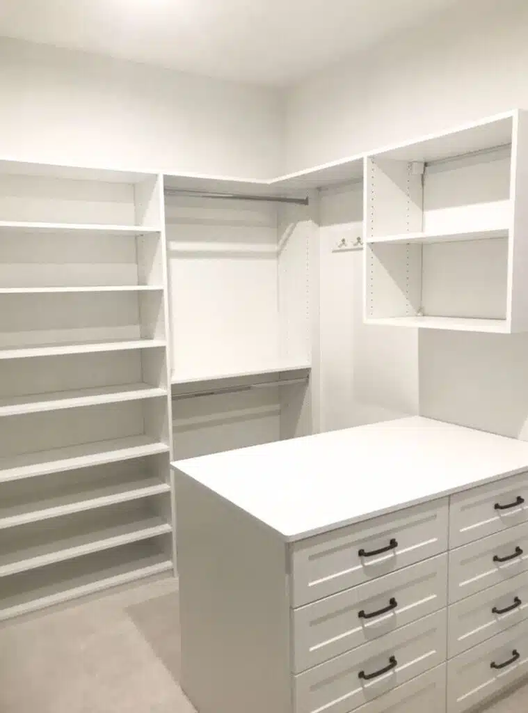 White walk-in closet with shoe shelving, long hang and drawer island